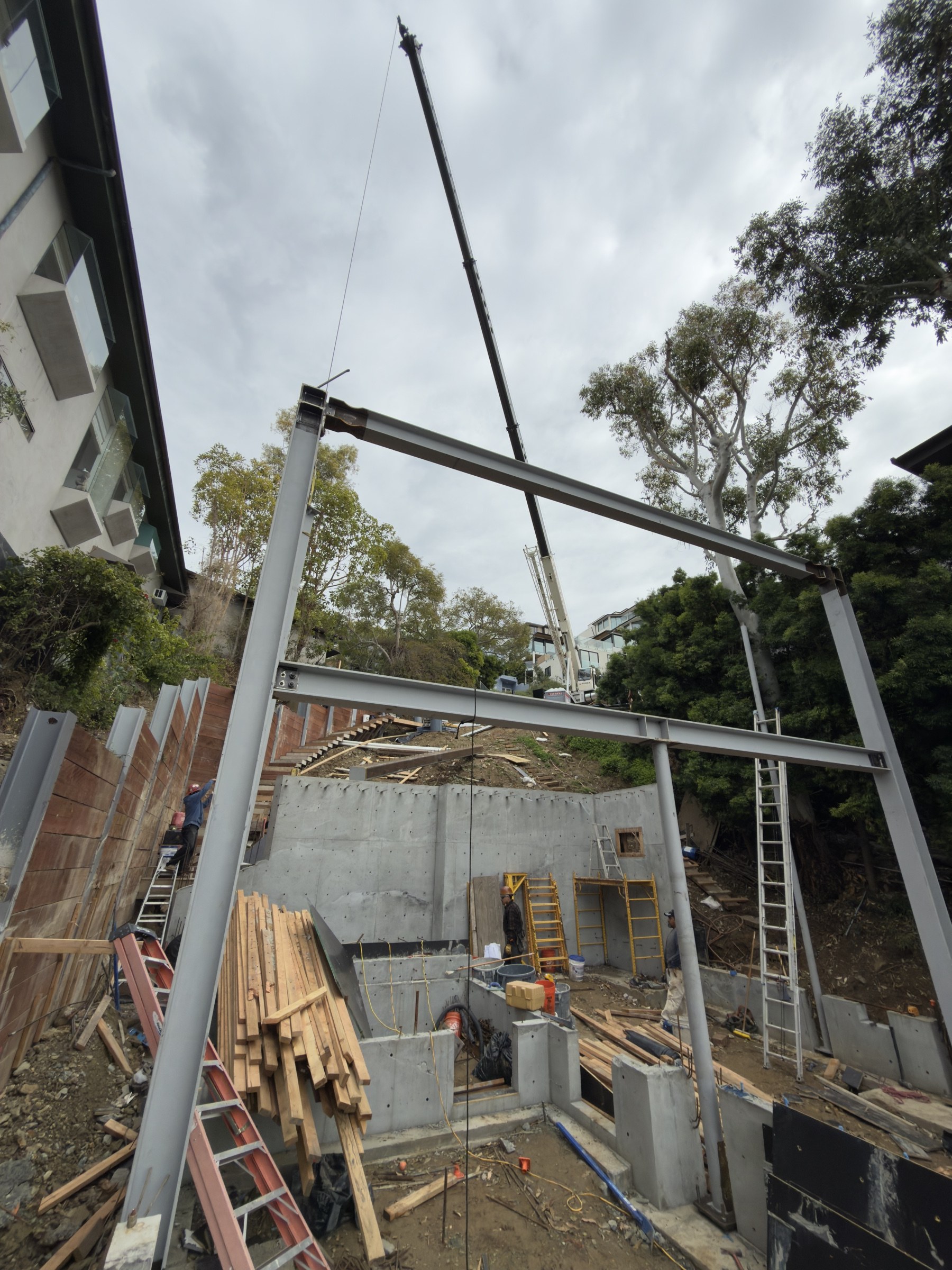 Crane setting steel on Alta Vista hillside